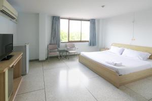 a hotel room with a bed and a television at Tokyo Hotel in Ubon Ratchathani