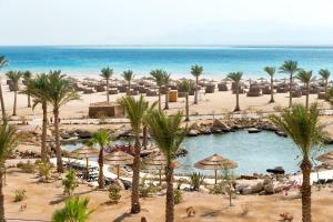 een uitzicht op een strand met palmbomen en een zwembad bij Robinson Soma Bay in Hurghada