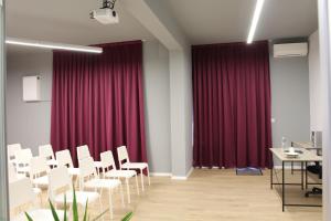 a conference room with red curtains and white chairs at Hotel39 in Plovdiv