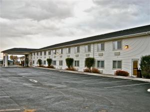 a large white building with a parking lot at Rory & Ryan Inn in Burns