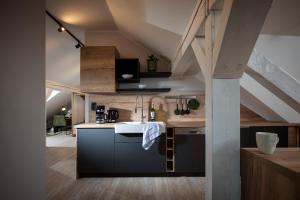 an attic kitchen with a sink and a counter at Berg und Tal Hotel & Apartments in Braunlage
