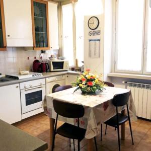 eine Küche mit einem Tisch und einer Blumenvase darauf in der Unterkunft Casa Vida in Cremona