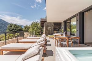 um pátio exterior com espreguiçadeiras e uma piscina em Arua Private Spa Villas em Merano