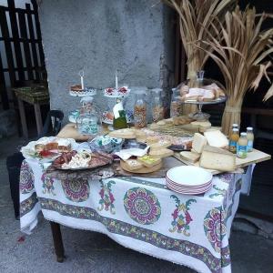 un tavolo con cibo e piatti sopra di B&B Stella Al Pina a Tezze