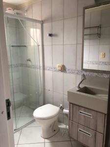 y baño con ducha, aseo y lavamanos. en LINDO APARTAMENTO EM MEIA PRAIA-1 quadra do mar! Melhor localização!, en Itapema