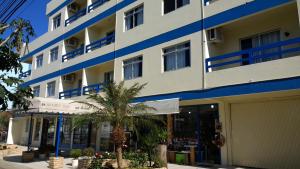 a building with a palm tree in front of it at Petit Praia Hotel in Florianópolis