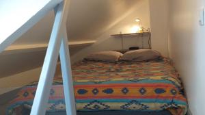 a bed with two pillows in a room at studio mezzanine 5 personnes in La Roche