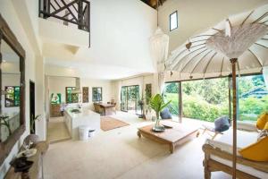 a large living room with a large umbrella at Teak Hill Pool Villa-Rosewood in Ko Chang