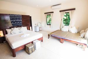 a bedroom with two beds and two windows at Teak Hill Pool Villa-Rosewood in Ko Chang +32 photos