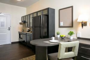 a kitchen with a table and a refrigerator at Candlewood Suites - Jacksonville - Mayport, an IHG Hotel in Jacksonville