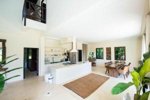 a living room with a kitchen and a table at Teak Hill Pool Villa-Rosewood in Ko Chang