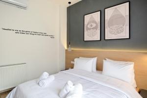 雅典的住宿－Odyssey Residence，一间卧室配有一张带白色毛巾的床