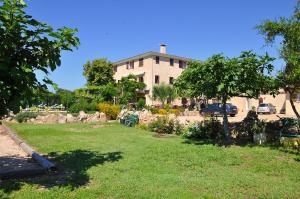 een huis met een tuin met een boom en een gebouw bij Résidence Casa Favalella in Porto Pollo