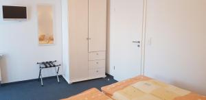 a bedroom with a bed and a white cabinet at Gästehaus Am Hothertor in Görlitz