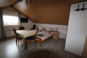 1 dormitorio con 1 cama, mesa y sillas en Haus Anne, en Neunkirchen
