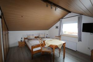 1 dormitorio con 1 cama, mesa y sillas en Haus Anne, en Neunkirchen