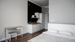 a bedroom with a white bed and a kitchen at HOTEL N°10 in Lviv