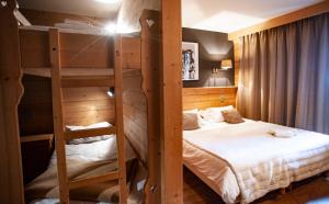 two bunk beds in a room with a bed at Hotel Le Monal in Sainte-Foy-Tarentaise