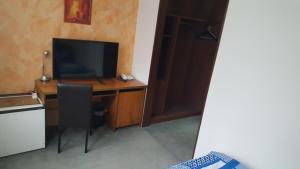 伍珀塔爾的住宿－Zimmer im Grünen，客房设有一张桌子、一台电视和一台电脑