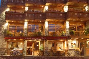 Un edificio con mesas y sillas delante. en Hotel Le Monal, en Sainte-Foy-Tarentaise