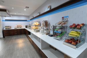 a kitchen with a counter with fruits and vegetables at Holiday Inn Express & Suites Toronto Airport West, an IHG Hotel in Mississauga