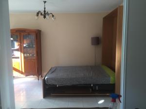 ein Schlafzimmer mit einem Bett in der Ecke eines Zimmers in der Unterkunft T3 Les Peupliers proche Pasino et mer in La Grande-Motte