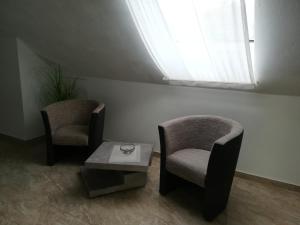 Habitación con 2 sillas, mesa y ventana en Hotel Ari en Kaiserslautern