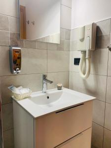 a bathroom with a sink and a phone on the wall at B&B Ninni in Castelbuono