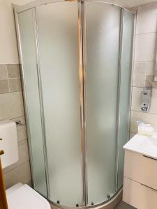 y baño con ducha y puerta de cristal. en B&B Ninni, en Castelbuono