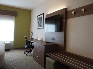 a hotel room with a desk and a bedroom at Holiday Inn Express Hotel & Suites Jacksonville North-Fernandina, an IHG Hotel in Yulee