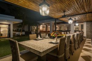 a dining room with a long table and chairs at Christina Estate by Villas Direct Bali in Seminyak