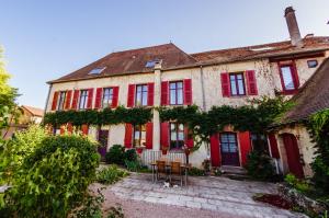 an old house with red shutters and a patio at Au Puy Des Vérités in Lapalisse