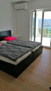a large bed in a room with a large window at Sea and Wind Villa Labin in Labin