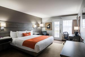 ein Hotelzimmer mit einem großen Bett und einem Schreibtisch in der Unterkunft Amsterdam Inn & Suites Moncton in Moncton
