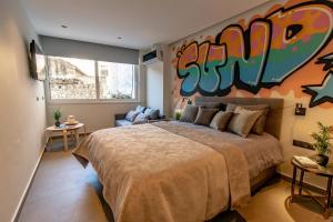 Triple A - Graffiti Homage in Psirri Square - FREE Parking! في أثينا: غرفة نوم بسرير كبير عليها لوحة على الحائط
