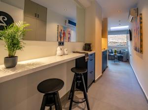 a kitchen with two bar stools and a counter top at Triple A - Graffiti Homage in Psirri Square - FREE Parking! in Athens +51 photos