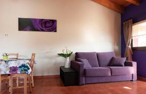 sala de estar con sofá púrpura y mesa en Apartamentos Vega Rodiles el balcón en Villaviciosa
