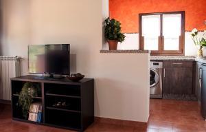 a kitchen with a flat screen tv on a stand at Apartamentos Vega Rodiles el balcón in Villaviciosa