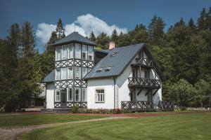 a large white house with a black roof at Boutique Hotel Bersas in Turaida