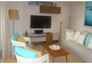 un salon avec un canapé et une télévision dans l'établissement Althea's stylish,homely apartment on the beach by Althea Holidays - AH 7, à Grand Baie