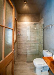 a bathroom with a toilet and a glass shower at Casa California Guesthouse in Valparaíso