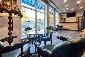 a living room with a table and chairs at Boutique Hotel Dacha Lanzheron in Odesa