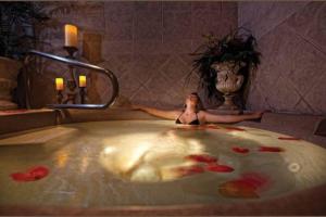 a woman sitting in a bath tub with red flowers at 4.5 Star!~Come to Paradise~Utah Alps~back door ski in Park City