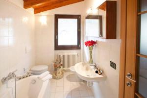 a white bathroom with a sink and a toilet and a sink at Argegno Penthouse in Argegno +38 photos
