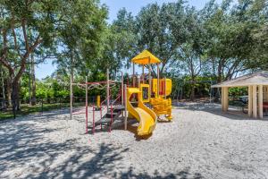a playground with a yellow slide and swings at Sans Souci in Naples