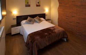a bedroom with a bed and a brick wall at Apartamento Vega Rodiles El Valle in Villaviciosa