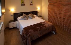 ein Schlafzimmer mit einem Bett und einer Ziegelwand in der Unterkunft Apartamento Vega Rodiles El Valle in Villaviciosa