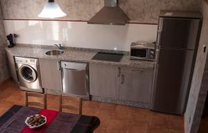 a kitchen with a stainless steel refrigerator and a table at Apartamento Vega Rodiles El Valle in Villaviciosa