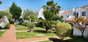 una casa con un patio con árboles y arbustos en Nerja Villas-Capistrano, en Nerja