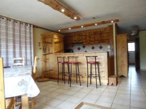 a kitchen with bar stools and a counter top at Chalet Les Liouès in Sollières-Sardières